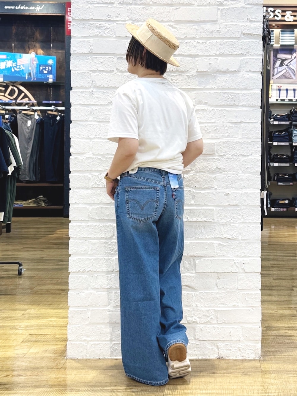ホワイト系のTシャツ/カットソー、ブルー系のデニムパンツ、ゴールド系のハンドバッグを着用したレディースの夏コーディネートの9枚目の写真