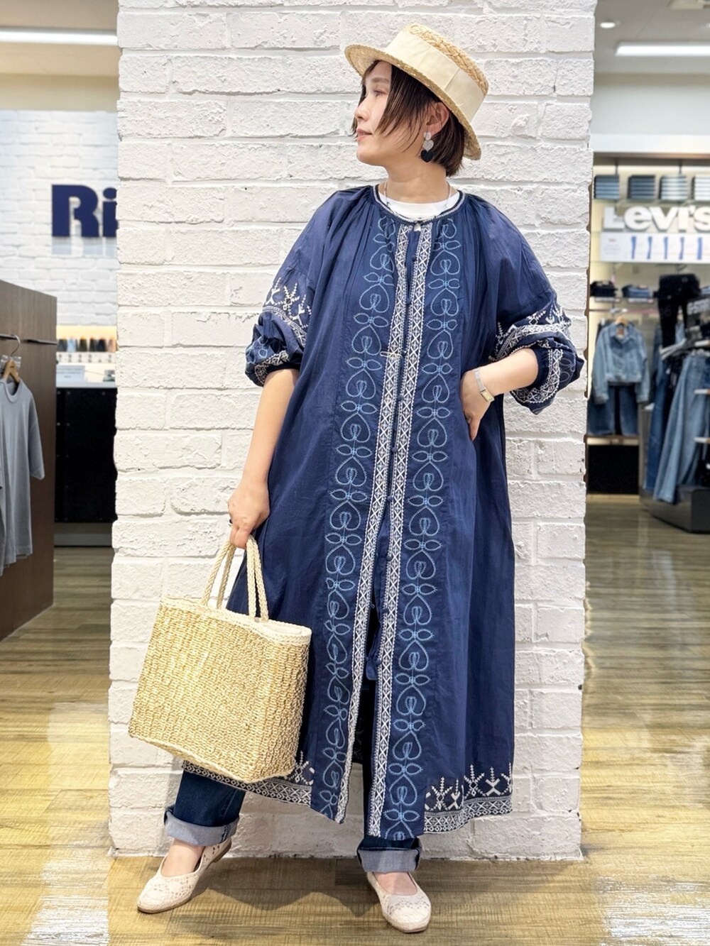 ブルー系のデニムパンツ、ブルー系のシャツワンピース、ホワイト系のTシャツ/カットソーを着用したレディースの春コーディネートの3枚目の写真