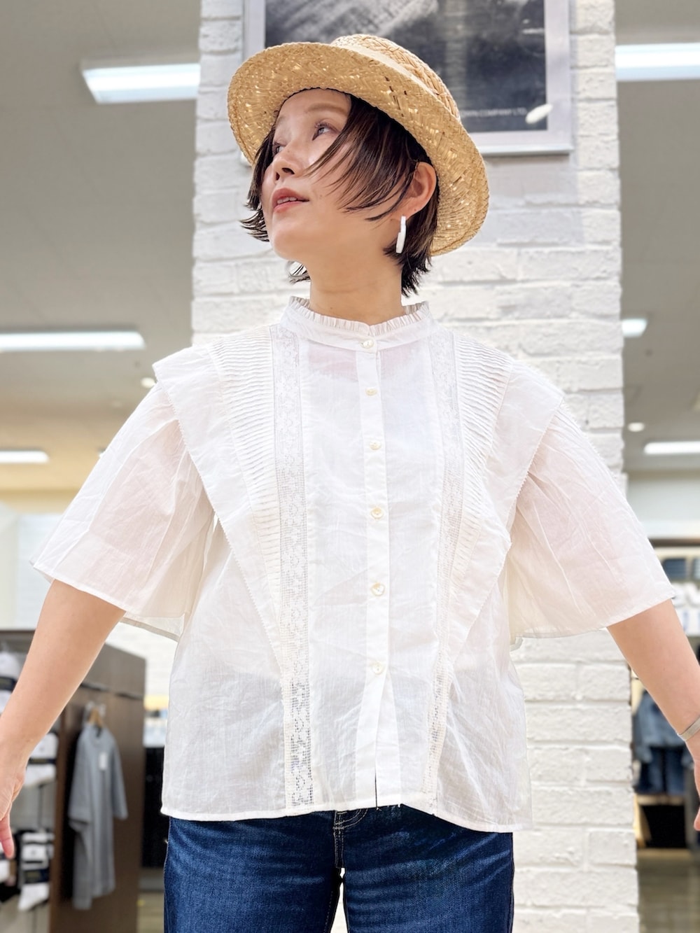 ブラック系のバレエシューズ、ゴールド系のかごバッグ、ブルー系のデニムパンツを着用したレディースの夏コーディネートの6枚目の写真