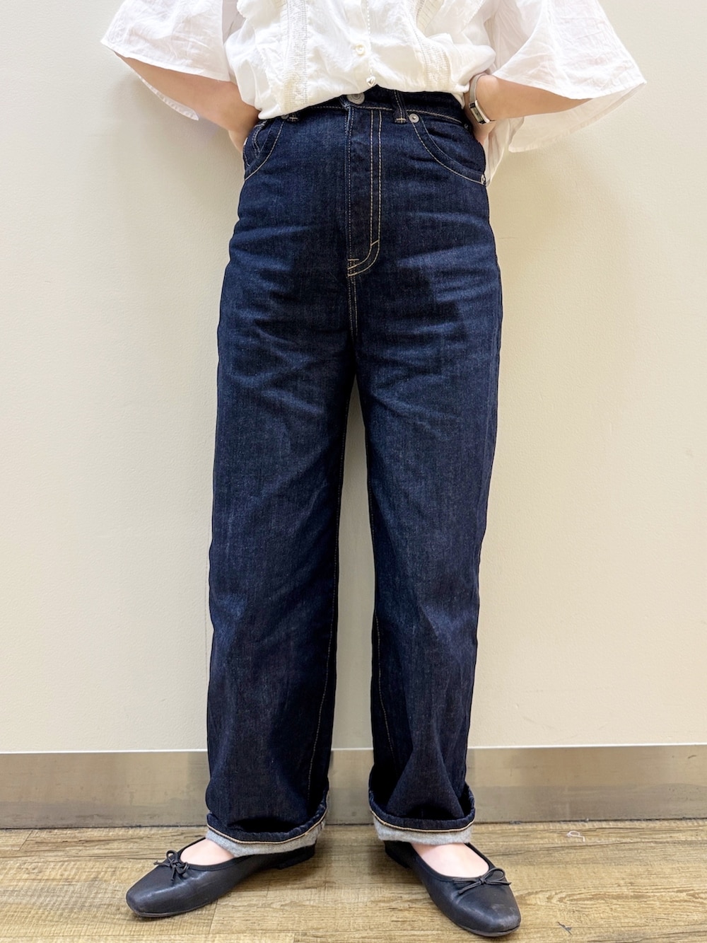 ブラック系のバレエシューズ、ゴールド系のかごバッグ、ブルー系のデニムパンツを着用したレディースの夏コーディネートの9枚目の写真