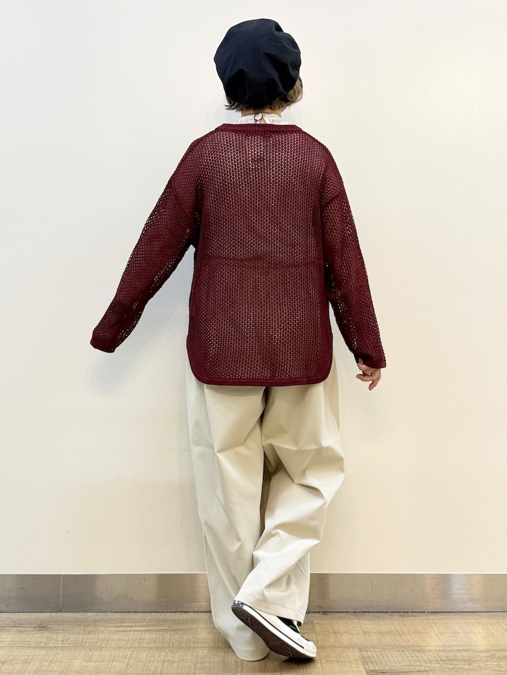 レッド系のニット/セーター、グレー系のその他パンツ、ブラック系のショルダーバッグを着用したレディースの秋コーディネートの5枚目の写真