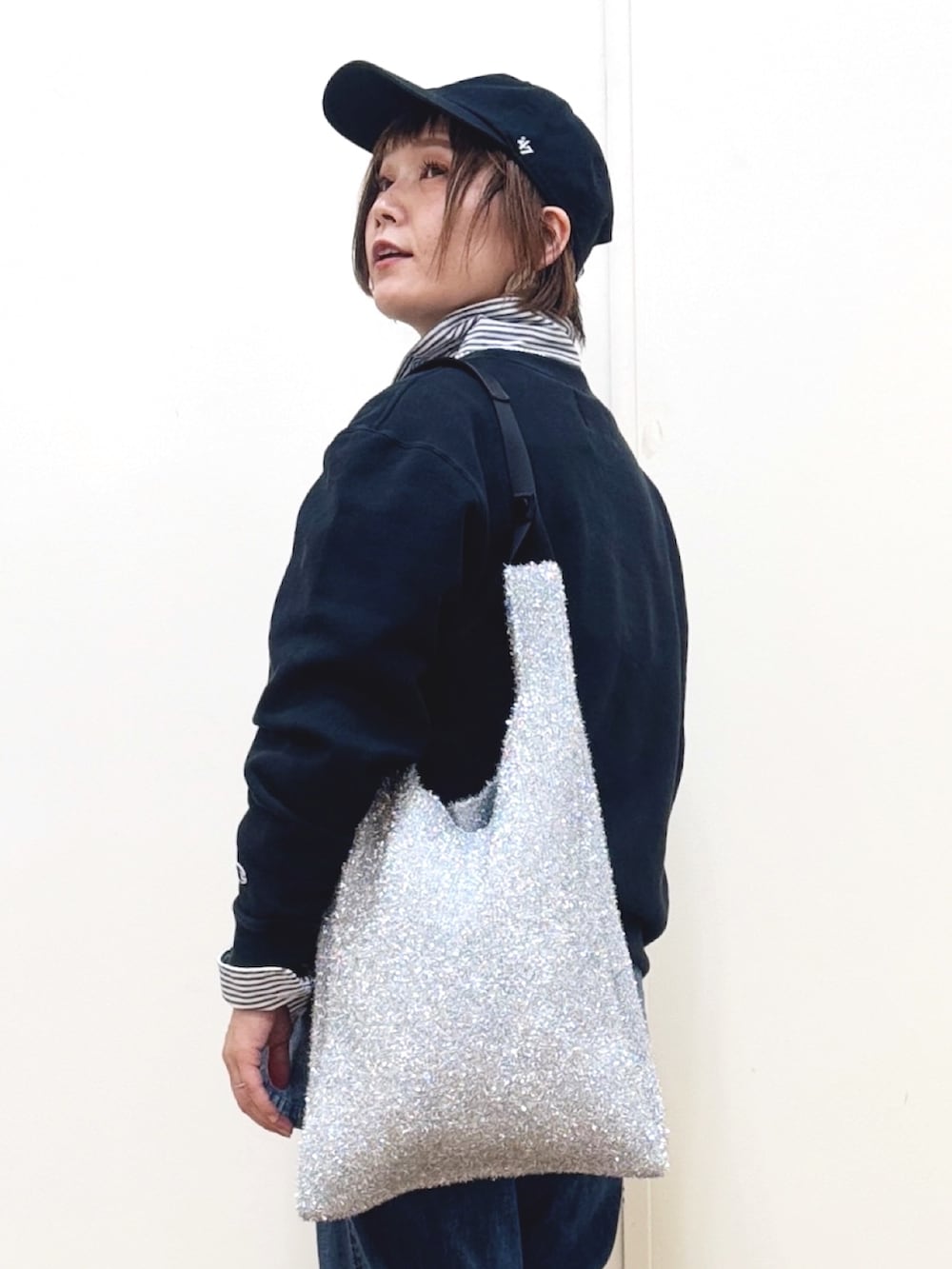 ブルー系のキャミソール、ブルー系のデニムパンツ、ブラック系のブーツを着用したレディースの冬コーディネートの10枚目の写真