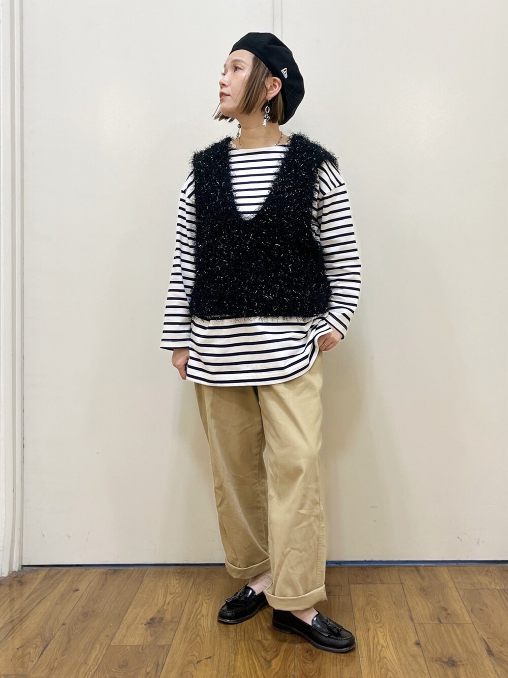 ベージュ系のチノパンツ、ブラック系のベスト、ブルー系のTシャツ/カットソーを着用したレディースの冬コーディネートの3枚目の写真
