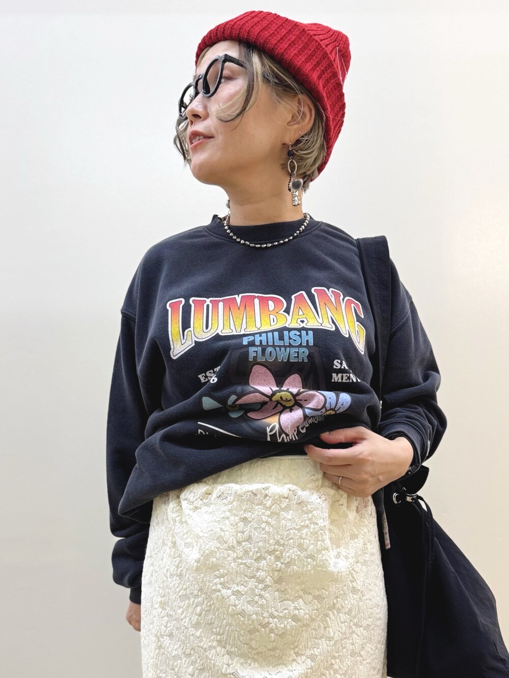 ホワイト系のスカート、ブラック系のスニーカー、ブラック系のショルダーバッグを着用したレディースの秋コーディネートの9枚目の写真