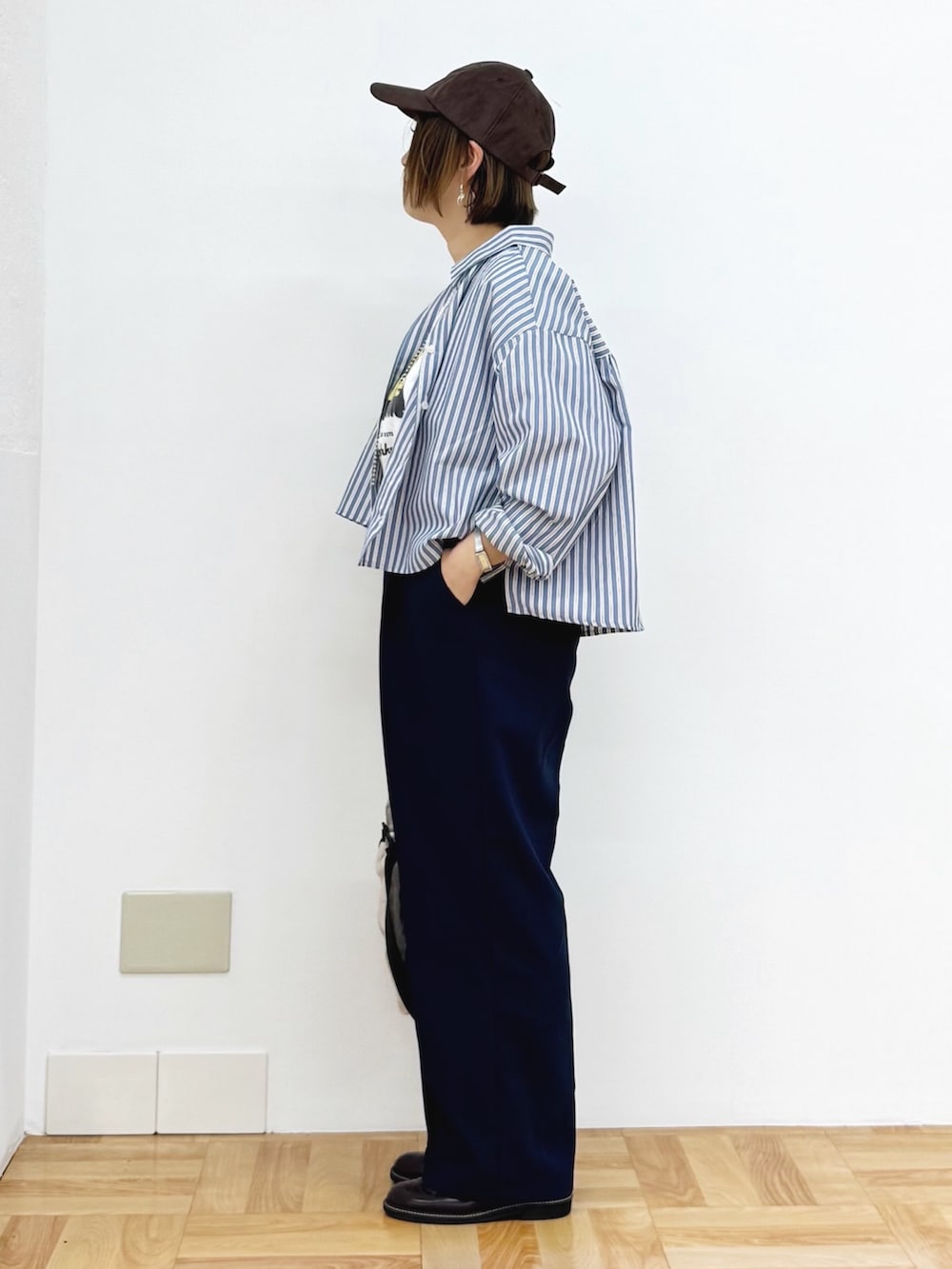 ホワイト系のショルダーバッグ、ブラウン系のドレスシューズ、ブルー系のその他パンツを着用したレディースの秋コーディネートの3枚目の写真