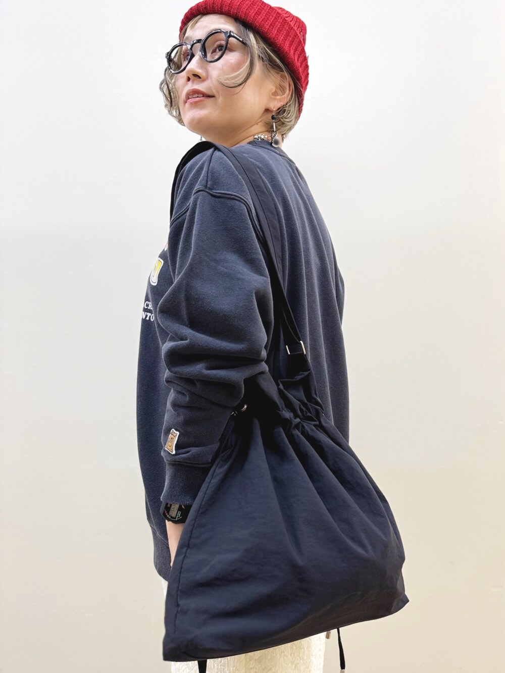 ホワイト系のスカート、ブラック系のスニーカー、ブラック系のショルダーバッグを着用したレディースの秋コーディネートの10枚目の写真