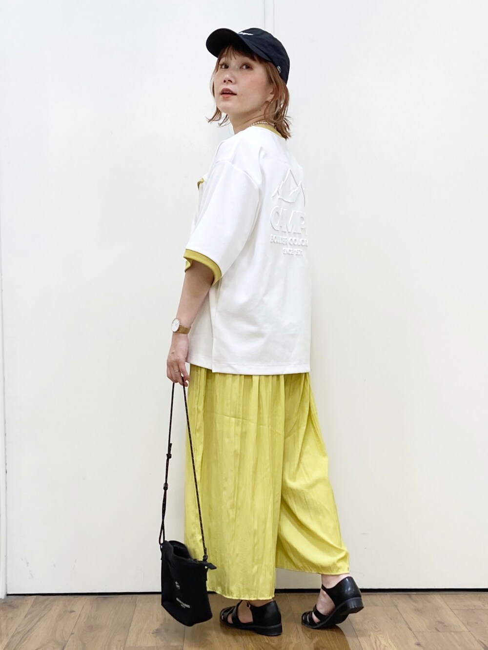 ホワイト系のTシャツ/カットソー、イエロー系のその他パンツ、ブラック系のショルダーバッグを着用したレディースの夏コーディネートの3枚目の写真