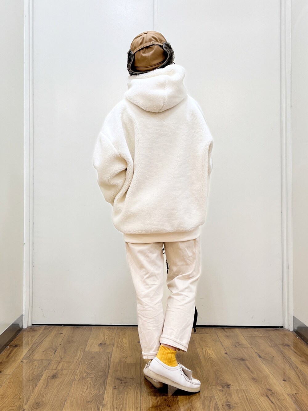ホワイト系のパーカー、ホワイト系のデニムパンツ、ホワイト系のモカシン/デッキシューズを着用したレディースの冬コーディネートの4枚目の写真