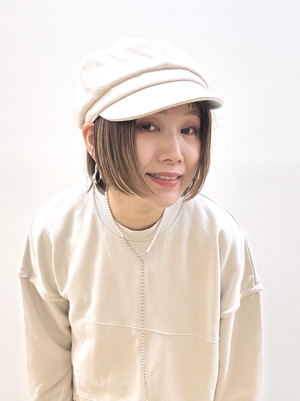 ベージュ系のスウェット、イエロー系のスカート、イエロー系のショルダーバッグを着用したレディースの秋コーディネートの10枚目の写真