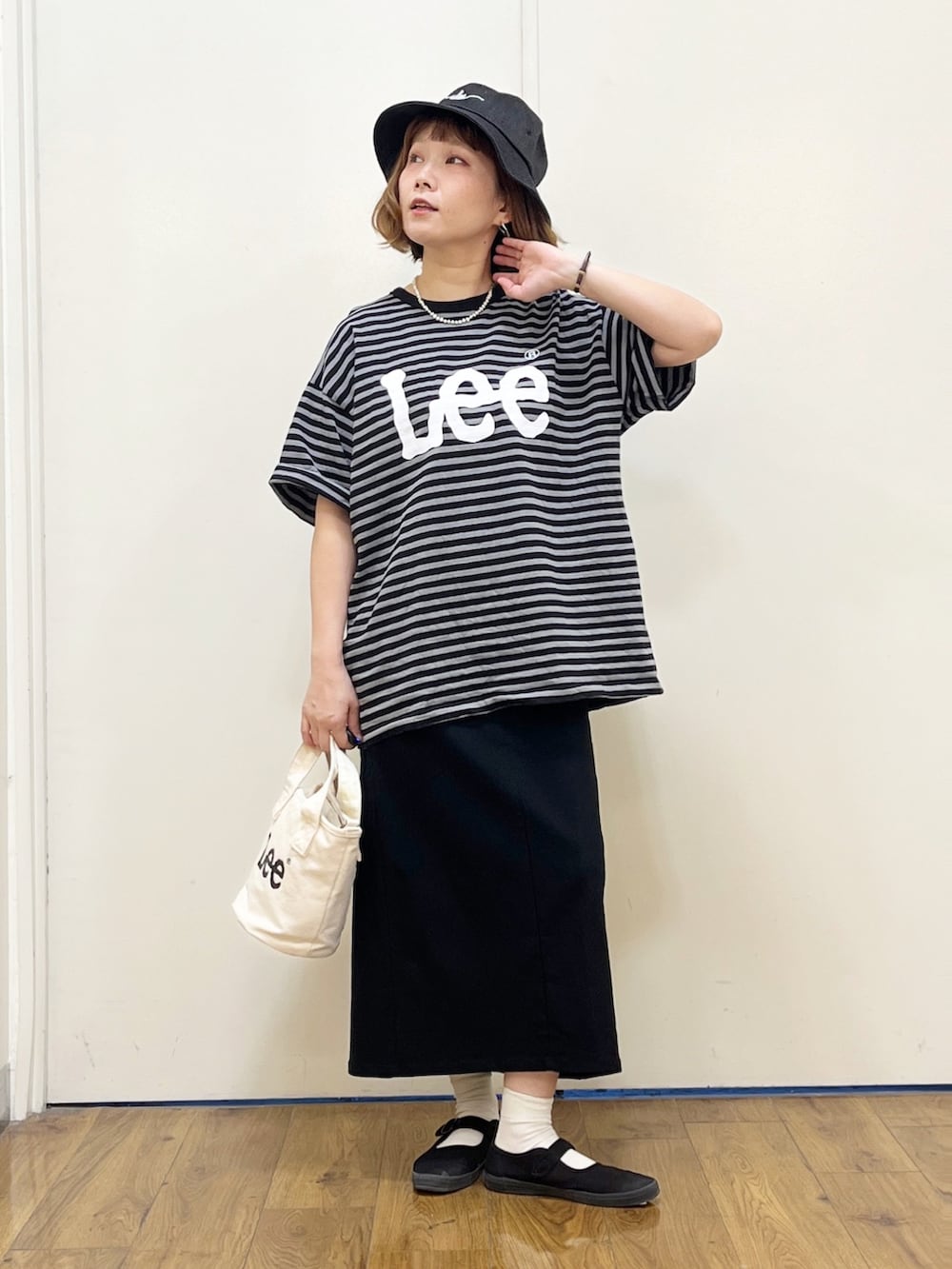 ホワイト系のショルダーバッグ、グレー系のTシャツ/カットソー、ブラック系のスニーカーを着用したレディースの春コーディネートの2枚目の写真