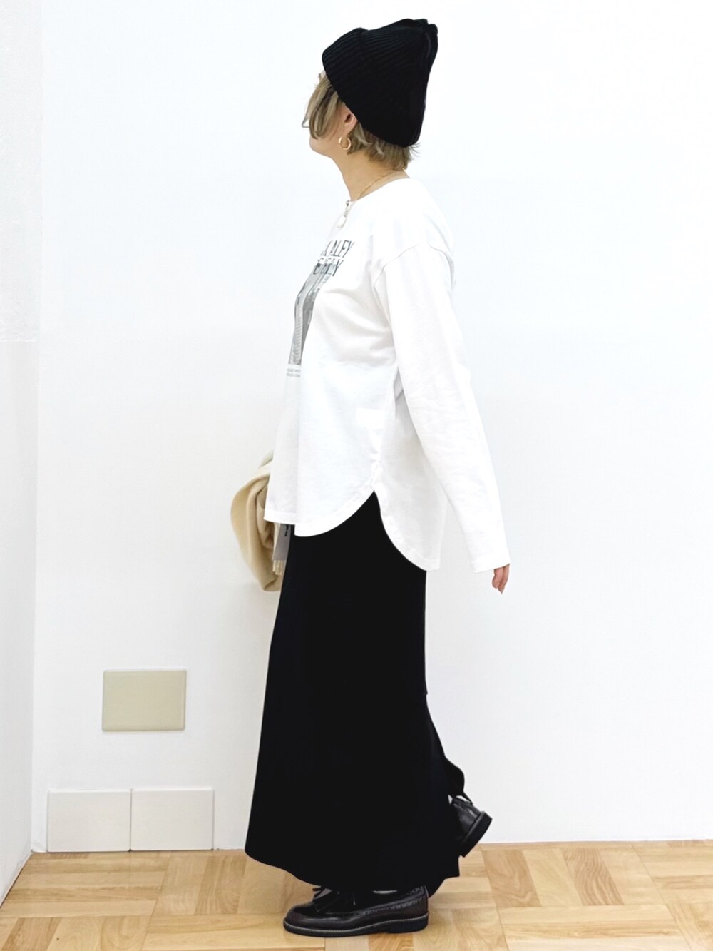 ブラック系のスカート、ホワイト系のTシャツ/カットソー、ブラック系のニットキャップ/ビーニーを着用したレディースの秋コーディネートの9枚目の写真