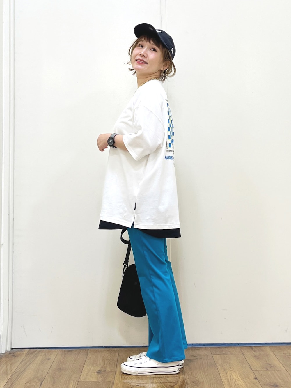 ブルー系のその他パンツ、グリーン系のショルダーバッグ、ホワイト系のスニーカーを着用したレディースの夏コーディネートの4枚目の写真