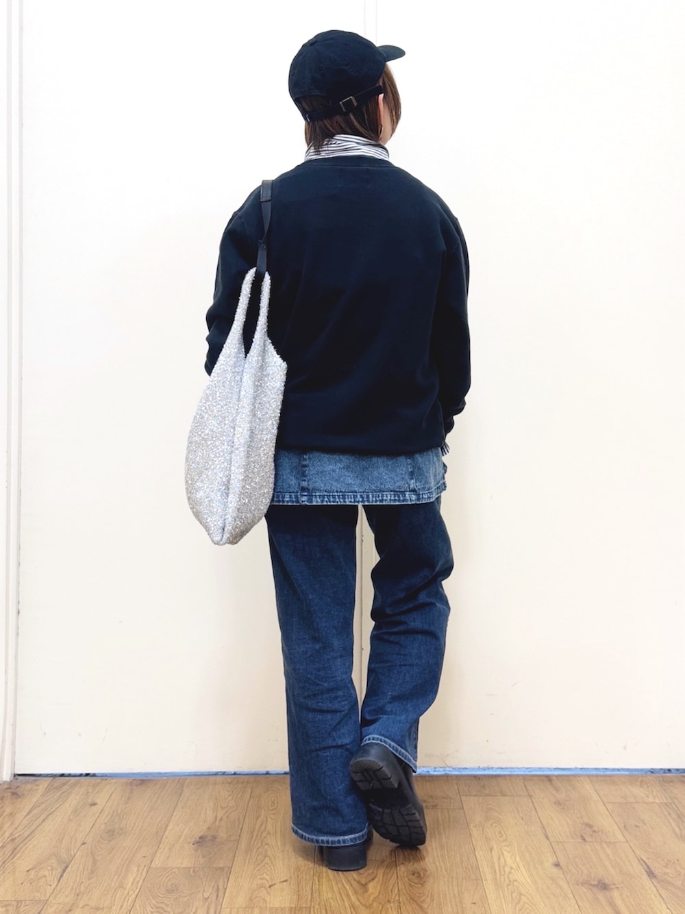 ブルー系のキャミソール、ブルー系のデニムパンツ、ブラック系のブーツを着用したレディースの冬コーディネートの3枚目の写真