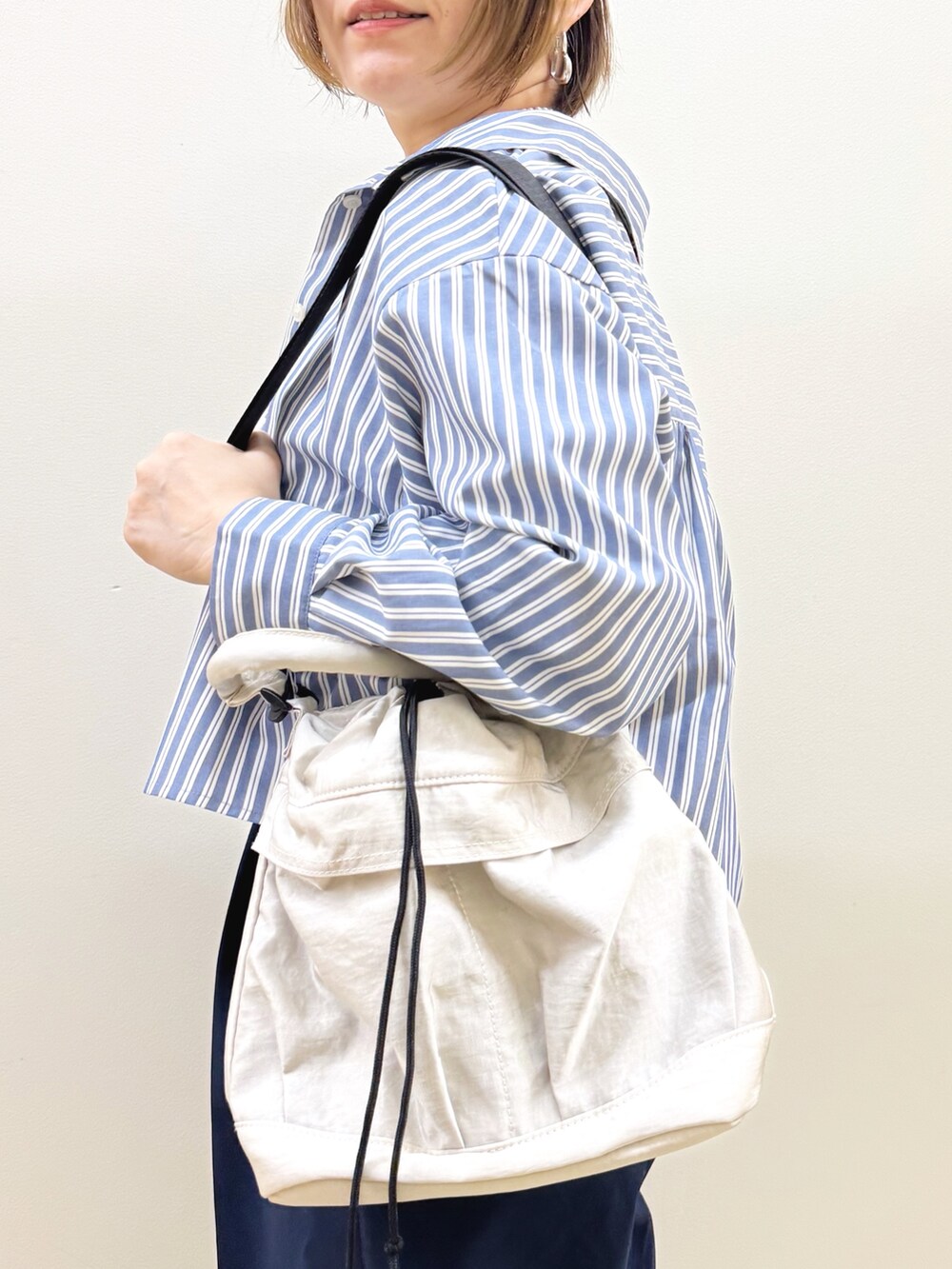 ホワイト系のショルダーバッグ、ブラウン系のドレスシューズ、ブルー系のその他パンツを着用したレディースの秋コーディネートの10枚目の写真