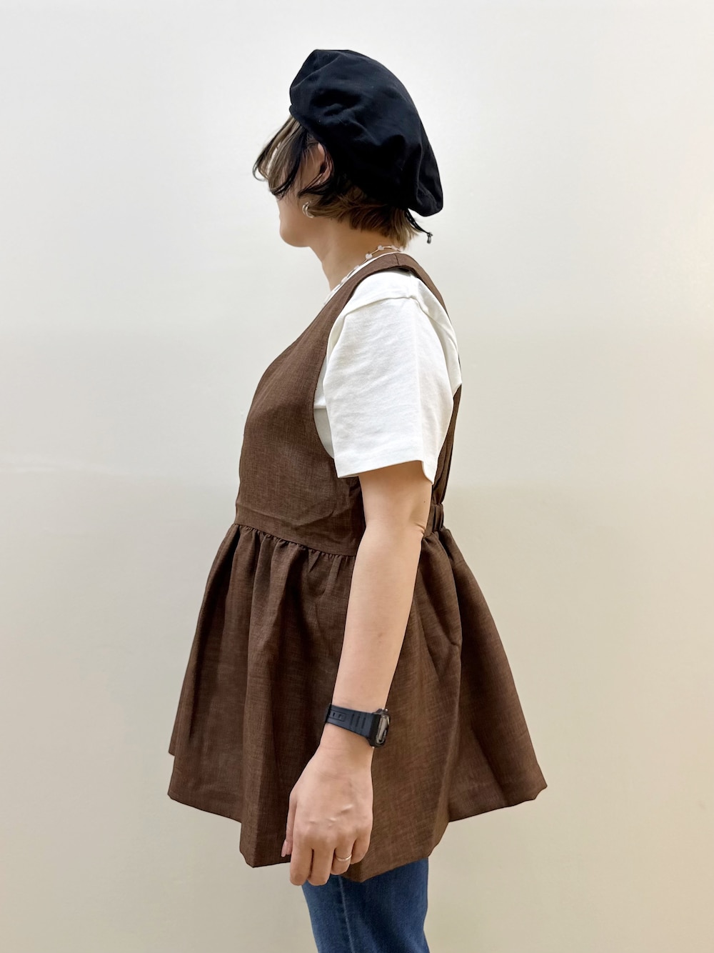 ブルー系のデニムパンツ、ホワイト系のTシャツ/カットソー、ブラウン系のベストを着用したレディースの夏コーディネートの4枚目の写真