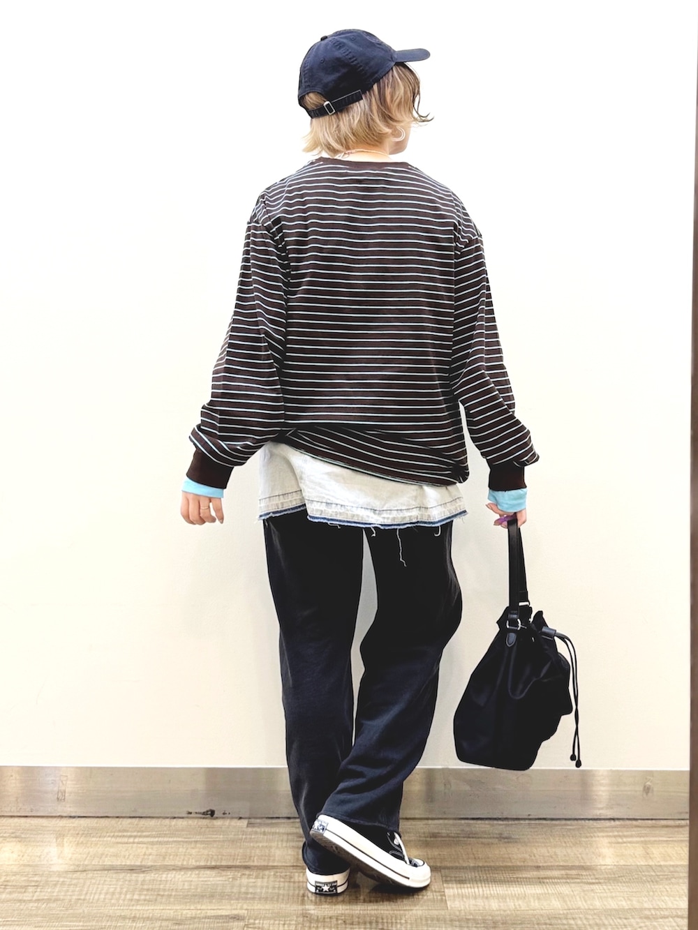 ブラック系のスウェットパンツ、ブラック系のショルダーバッグ、ブルー系のその他トップスを着用したレディースの冬コーディネートの5枚目の写真