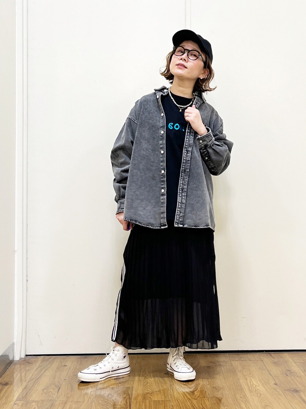 ブラック系のスカート、ブラック系のシャツ/ブラウス、ホワイト系のスニーカーを着用したレディースの春コーディネートの2枚目の写真