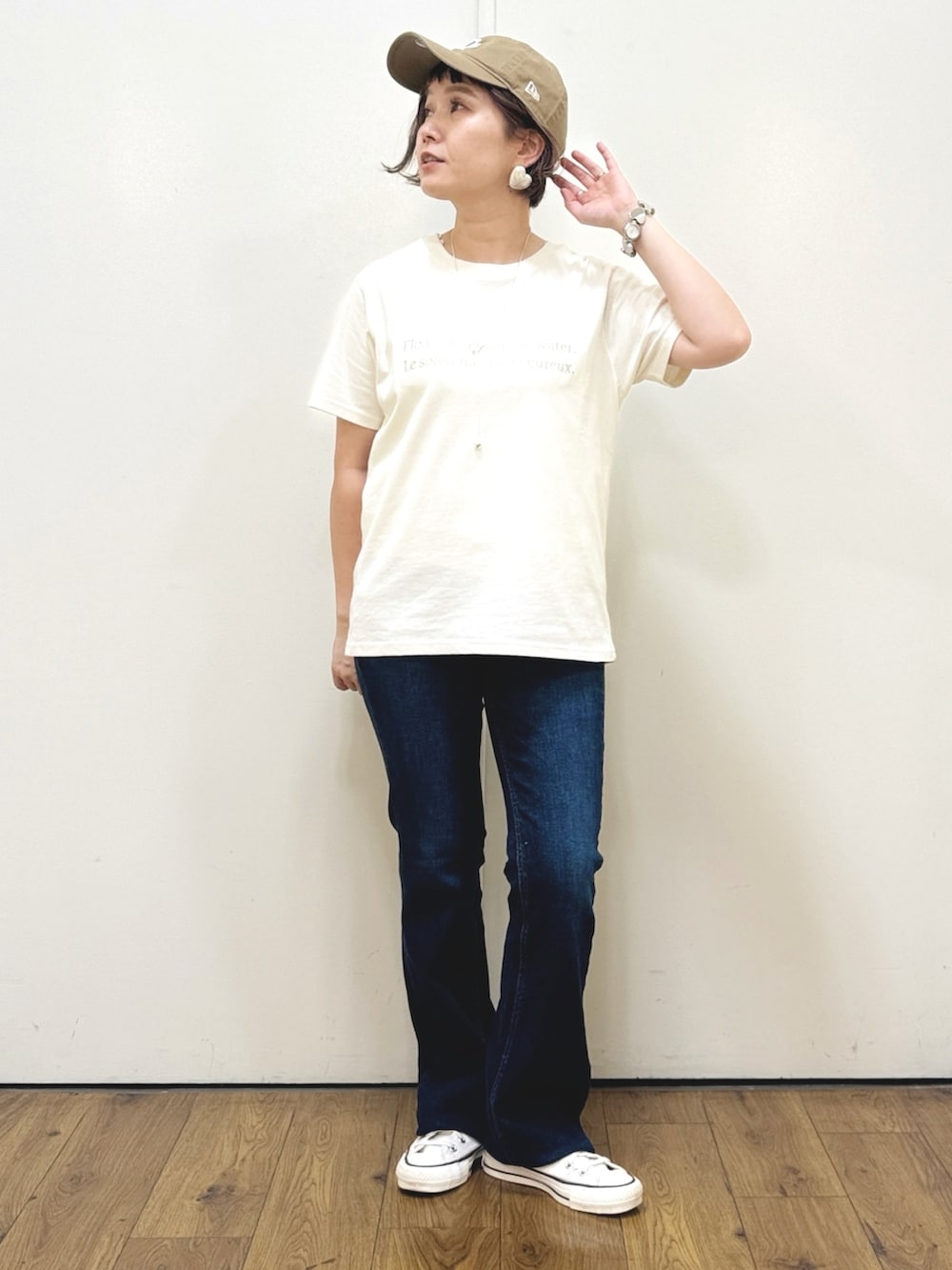 ホワイト系のベスト、ホワイト系のTシャツ/カットソー、ブルー系のデニムパンツを着用したレディースの秋コーディネートの3枚目の写真