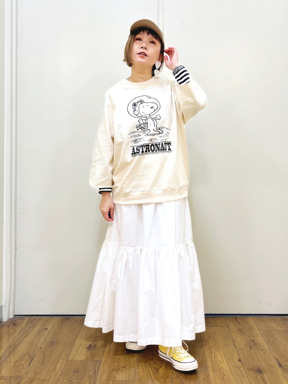 ホワイト系のTシャツ/カットソー、ホワイト系のスカート、イエロー系のスニーカーを着用したレディースの冬コーディネートの3枚目の写真