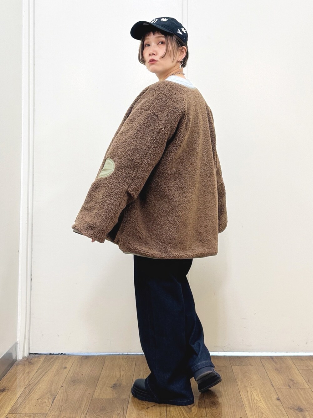 ブラック系のブーツ、ブルー系のデニムパンツ、グリーン系のブルゾンを着用したレディースの秋コーディネートの6枚目の写真