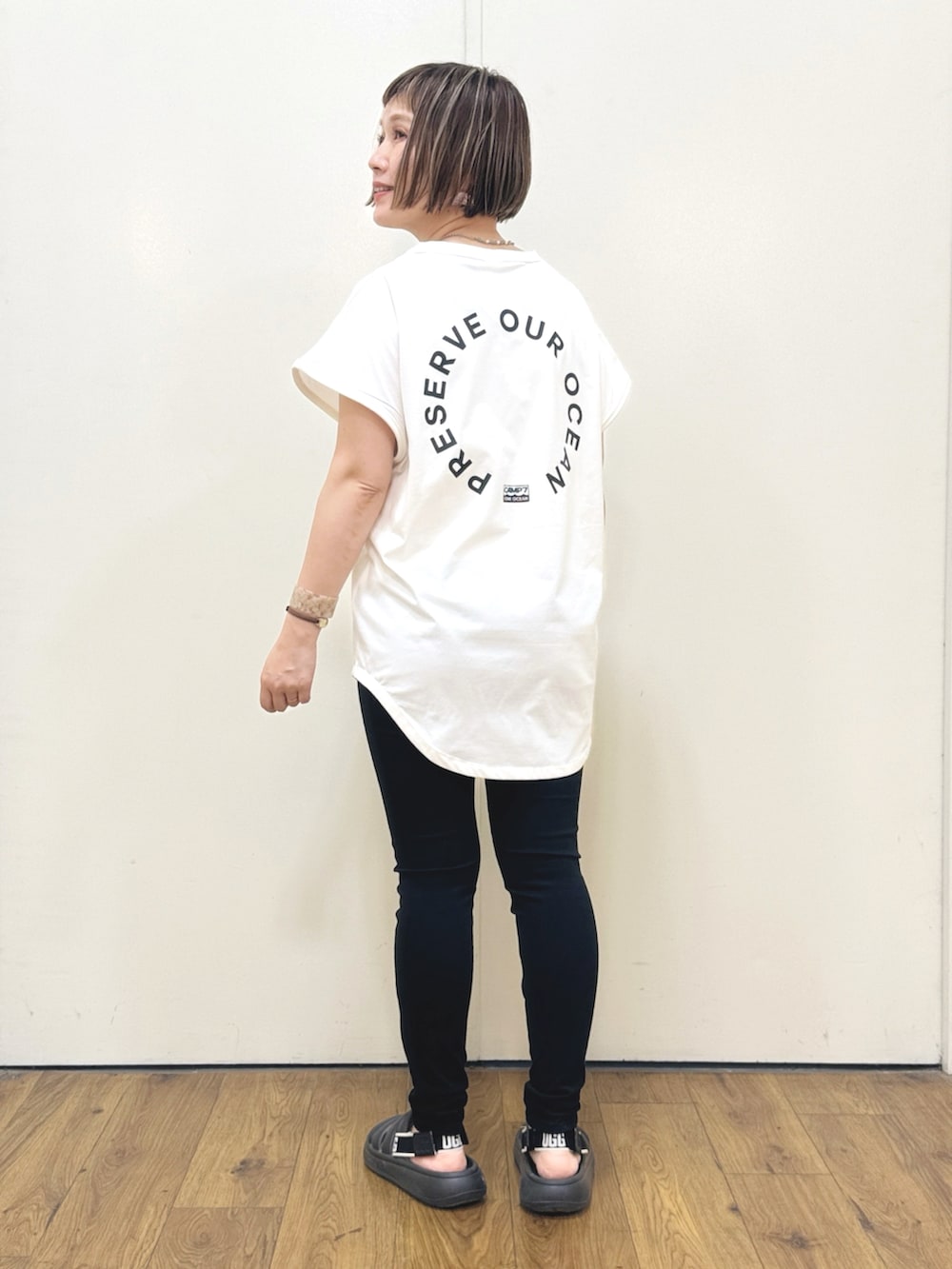 ホワイト系のTシャツ/カットソー、ブラック系のその他パンツ、ブラック系のサンダルを着用したレディースの春コーディネートの2枚目の写真