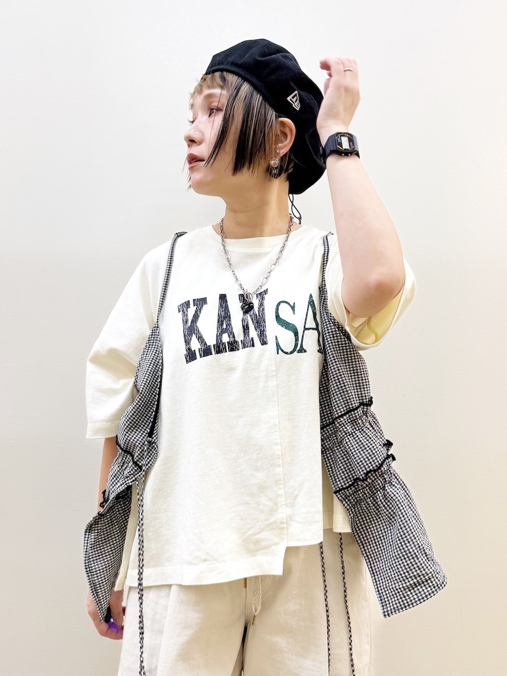 ブラック系のショルダーバッグ、ホワイト系のセットアップ、ホワイト系のTシャツ/カットソーを着用したレディースの夏コーディネートの2枚目の写真
