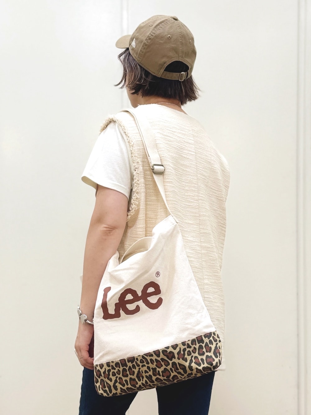 ホワイト系のベスト、ホワイト系のTシャツ/カットソー、ブルー系のデニムパンツを着用したレディースの秋コーディネートの5枚目の写真