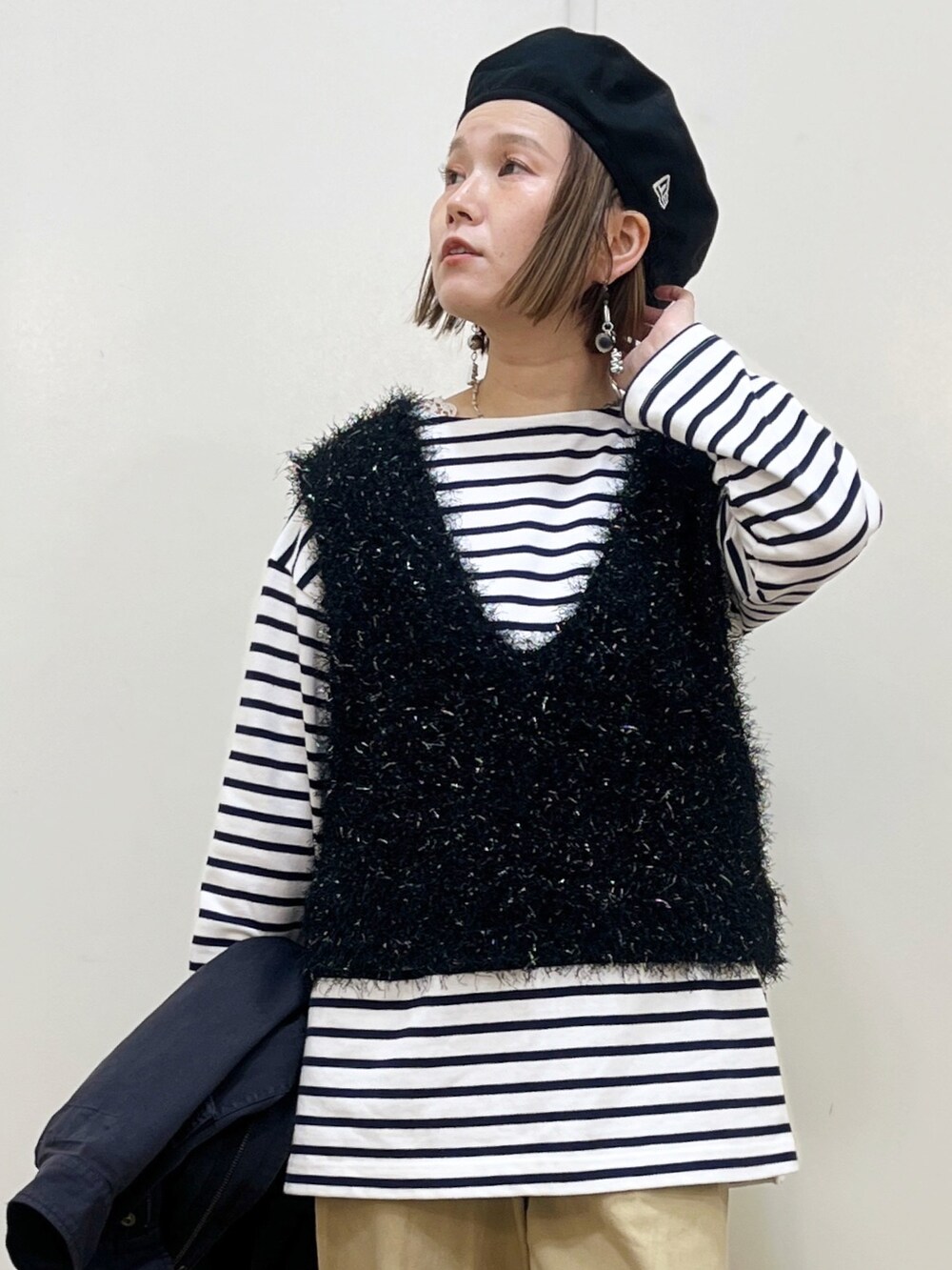 ベージュ系のチノパンツ、ブラック系のベスト、ブルー系のTシャツ/カットソーを着用したレディースの冬コーディネートの2枚目の写真