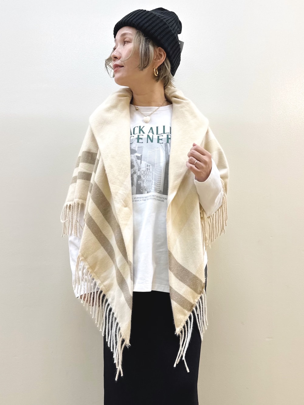 ブラック系のスカート、ホワイト系のTシャツ/カットソー、ブラック系のニットキャップ/ビーニーを着用したレディースの秋コーディネートの2枚目の写真