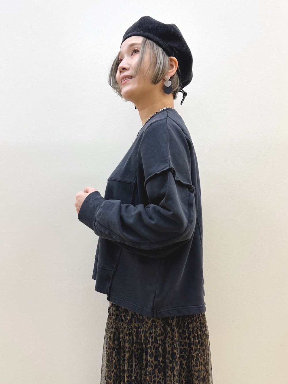 ブラック系のスウェット、ブラウン系のスカート、ホワイト系のショルダーバッグを着用したレディースの秋コーディネートの4枚目の写真