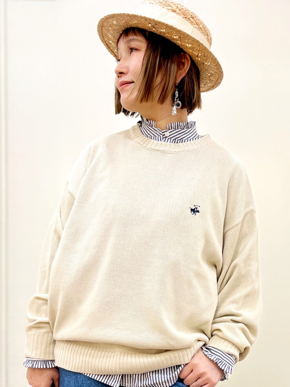 ホワイト系のトートバッグ、ホワイト系のニット/セーター、ブラック系のジャージを着用したレディースの春コーディネートの2枚目の写真