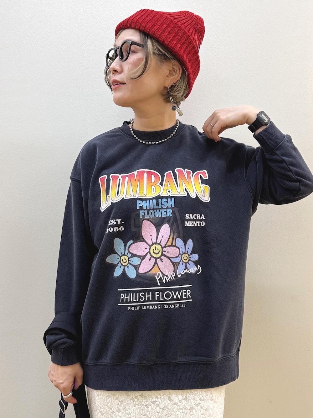 ホワイト系のスカート、ブラック系のスニーカー、ブラック系のショルダーバッグを着用したレディースの秋コーディネートの2枚目の写真