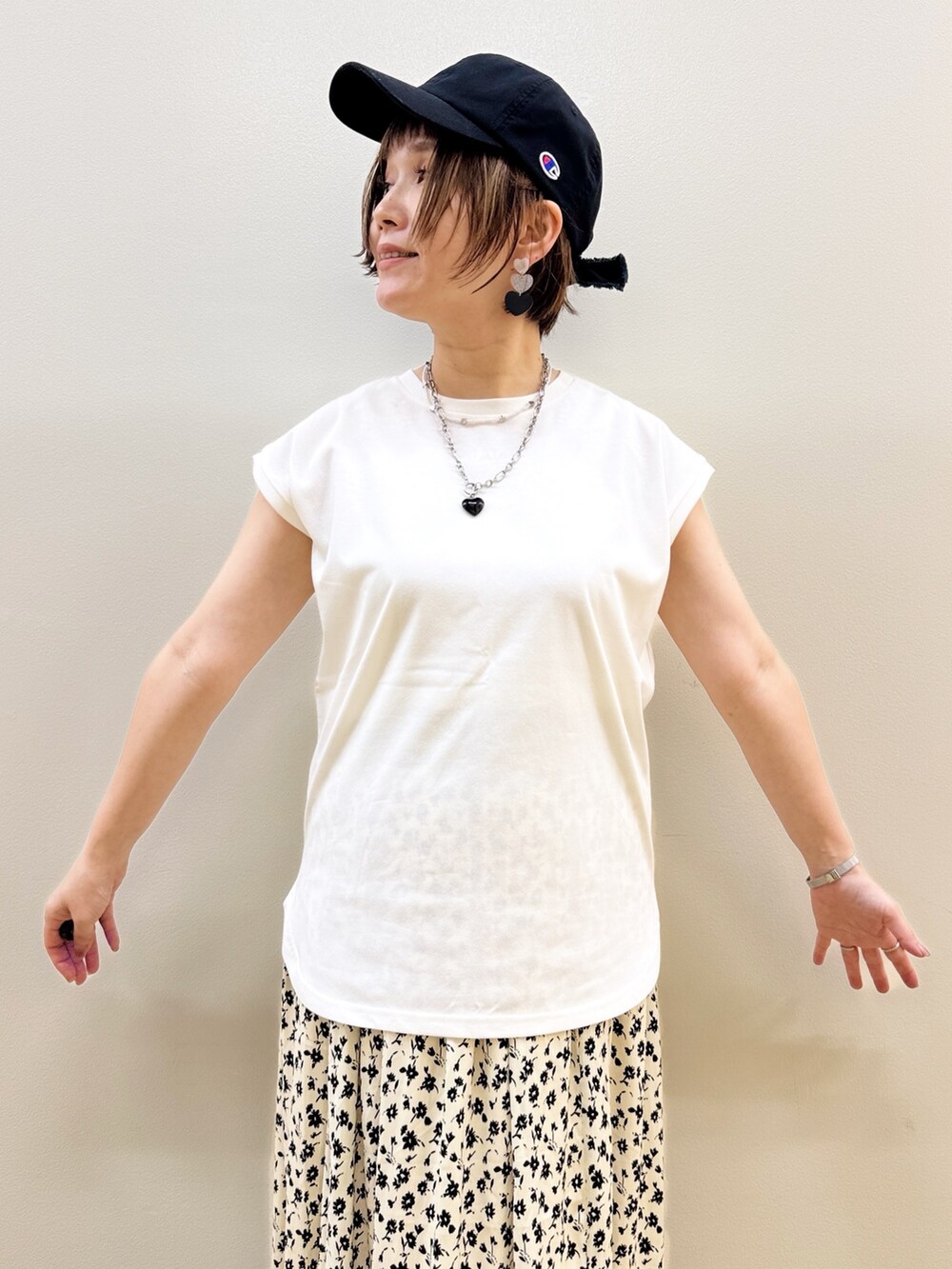 ピンク系のTシャツ/カットソー、ホワイト系のスカート、ブラック系のショルダーバッグを着用したレディースの春コーディネートの6枚目の写真