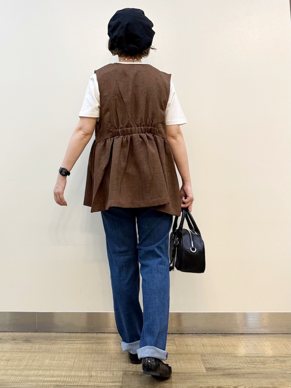 ブルー系のデニムパンツ、ホワイト系のTシャツ/カットソー、ブラウン系のベストを着用したレディースの夏コーディネートの5枚目の写真