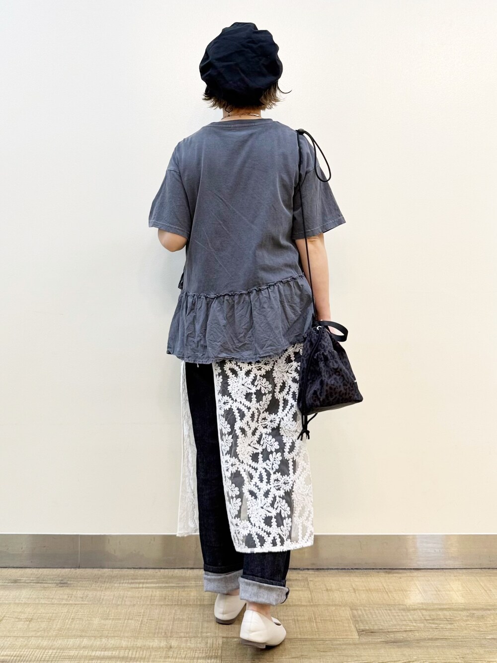 グレー系のTシャツ/カットソー、ホワイト系のスカート、ブラック系のデニムパンツを着用したレディースの春コーディネートの5枚目の写真