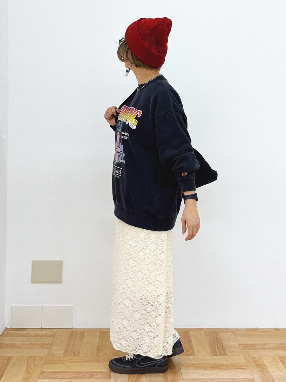 ホワイト系のスカート、ブラック系のスニーカー、ブラック系のショルダーバッグを着用したレディースの秋コーディネートの5枚目の写真