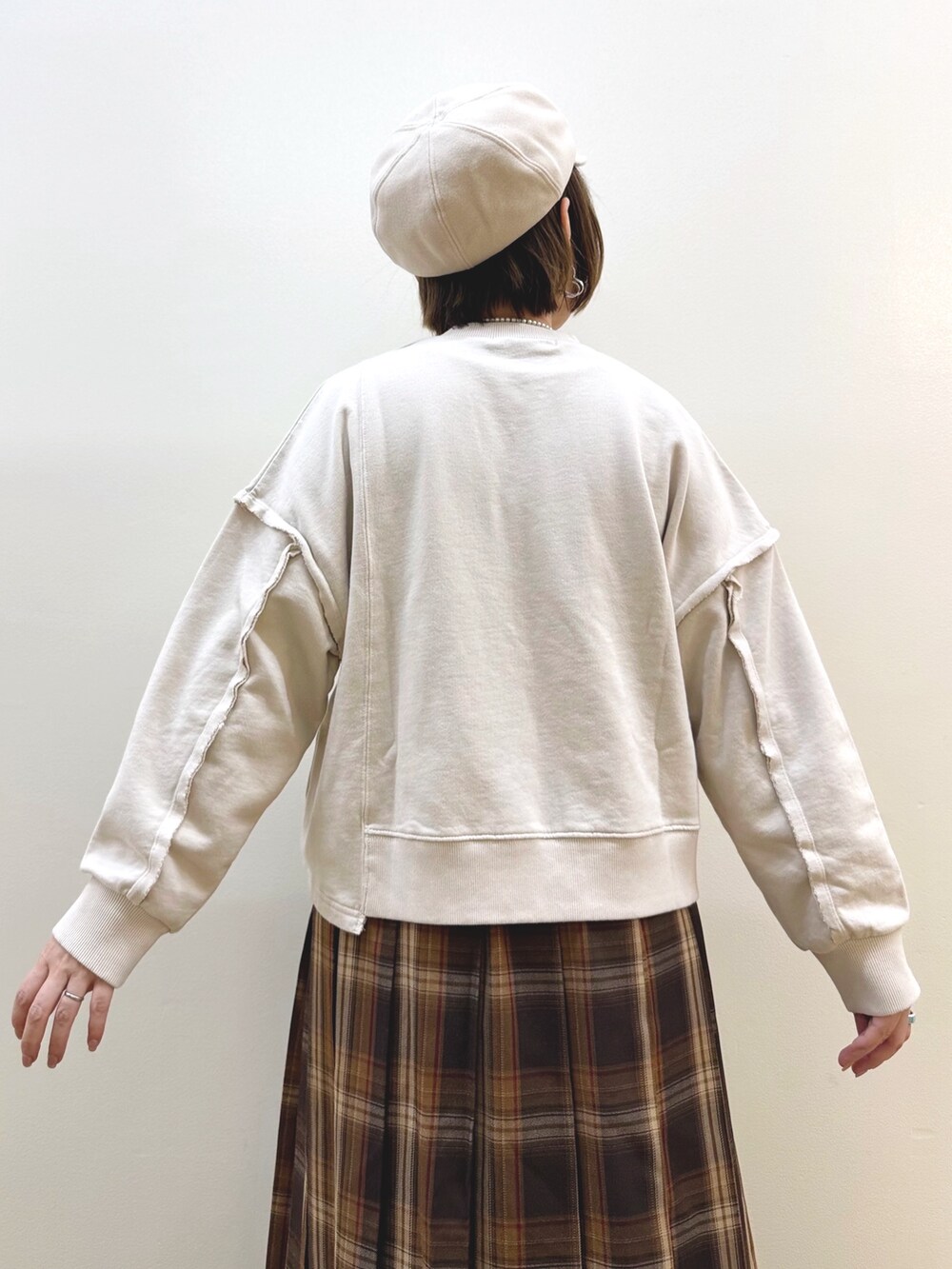 ベージュ系のスウェット、イエロー系のスカート、イエロー系のショルダーバッグを着用したレディースの秋コーディネートの6枚目の写真