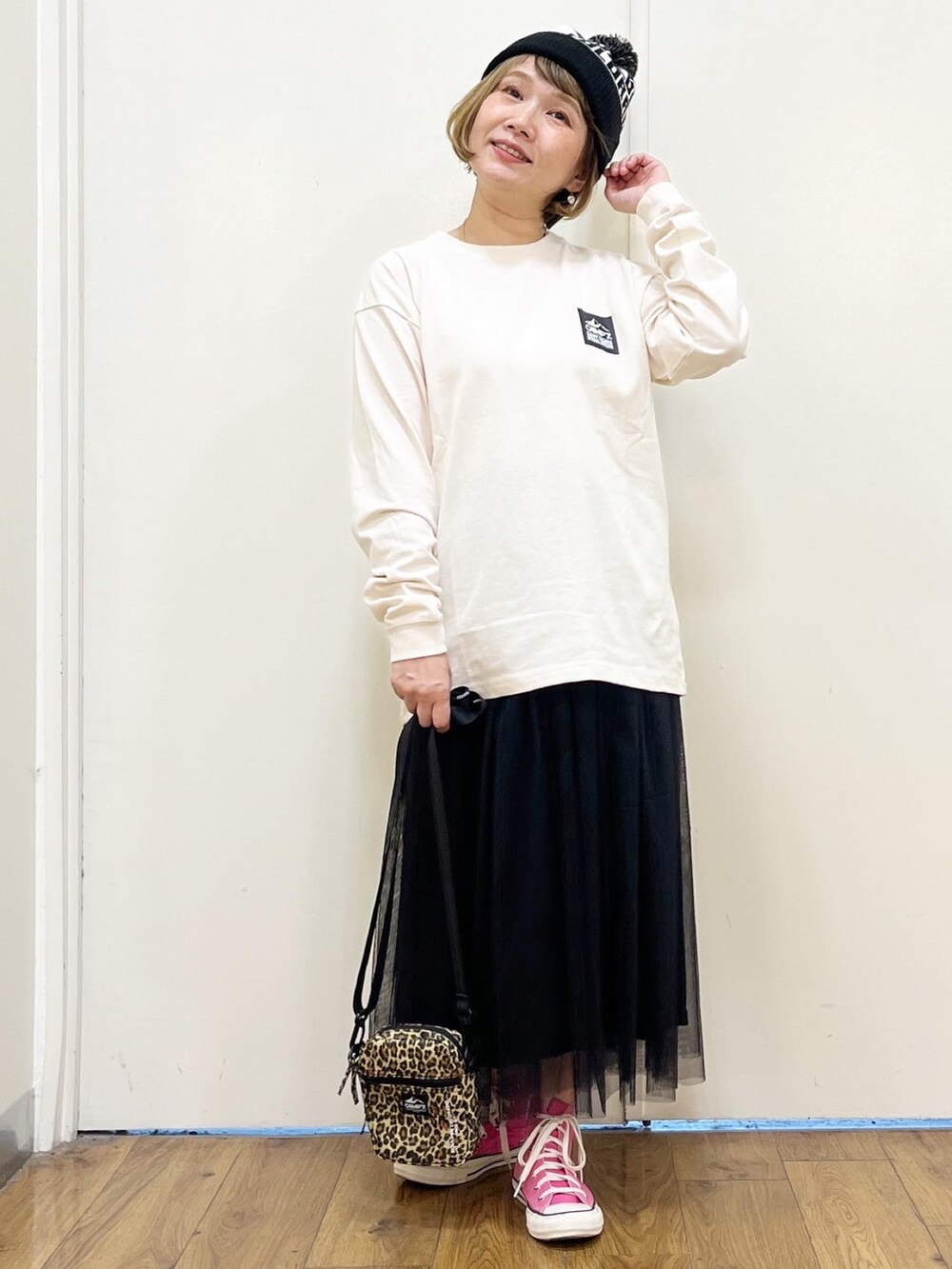 ホワイト系のTシャツ/カットソー、ブラック系のスカート、ベージュ系のショルダーバッグを着用したレディースの秋コーディネートの2枚目の写真