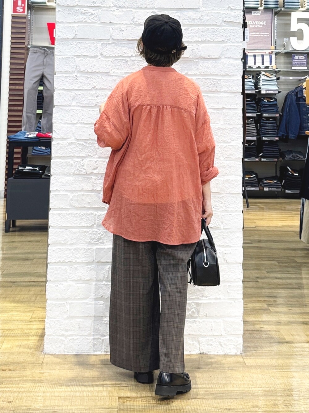 ホワイト系のTシャツ/カットソー、オレンジ系のシャツ/ブラウス、ブラック系のショルダーバッグを着用したレディースの秋コーディネートの6枚目の写真