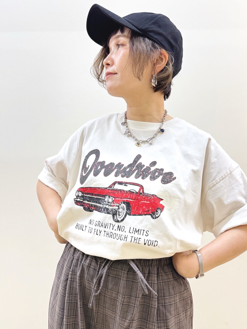 ホワイト系のTシャツ/カットソー、オレンジ系のシャツ/ブラウス、ブラック系のショルダーバッグを着用したレディースの秋コーディネートの9枚目の写真