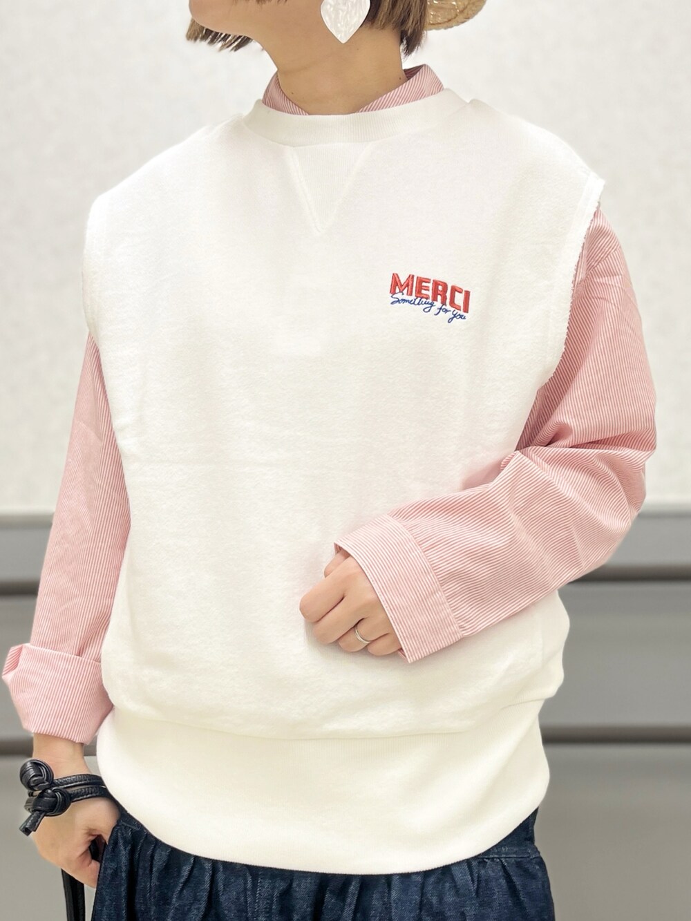 オレンジ系のシャツ/ブラウス、ブルー系のデニムスカート、ブラック系のショルダーバッグを着用したレディースの春コーディネートの3枚目の写真
