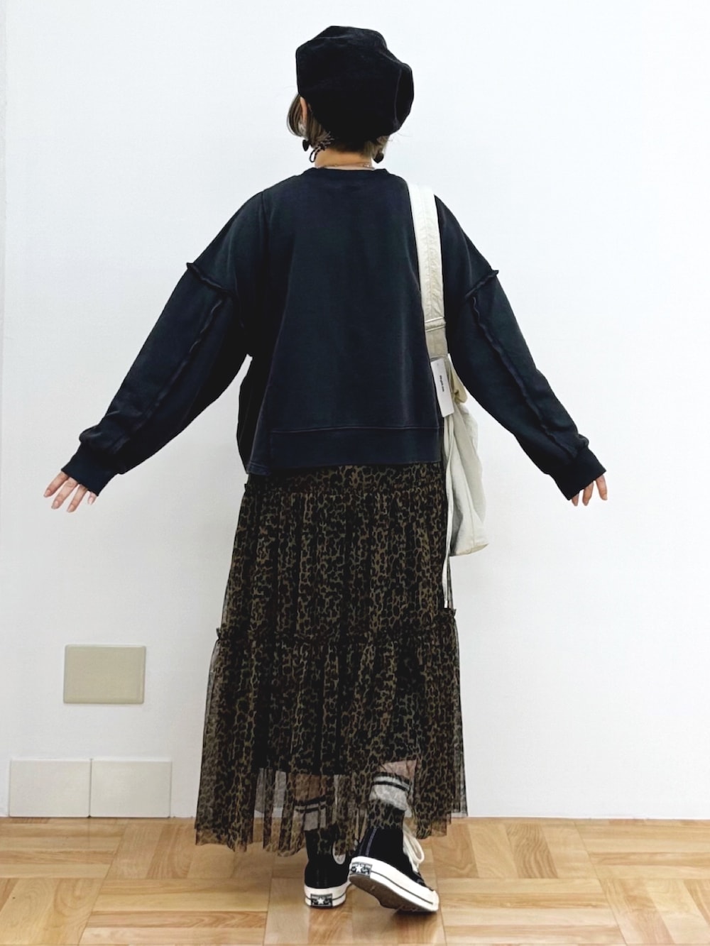 ブラック系のスウェット、ブラウン系のスカート、ホワイト系のショルダーバッグを着用したレディースの秋コーディネートの5枚目の写真