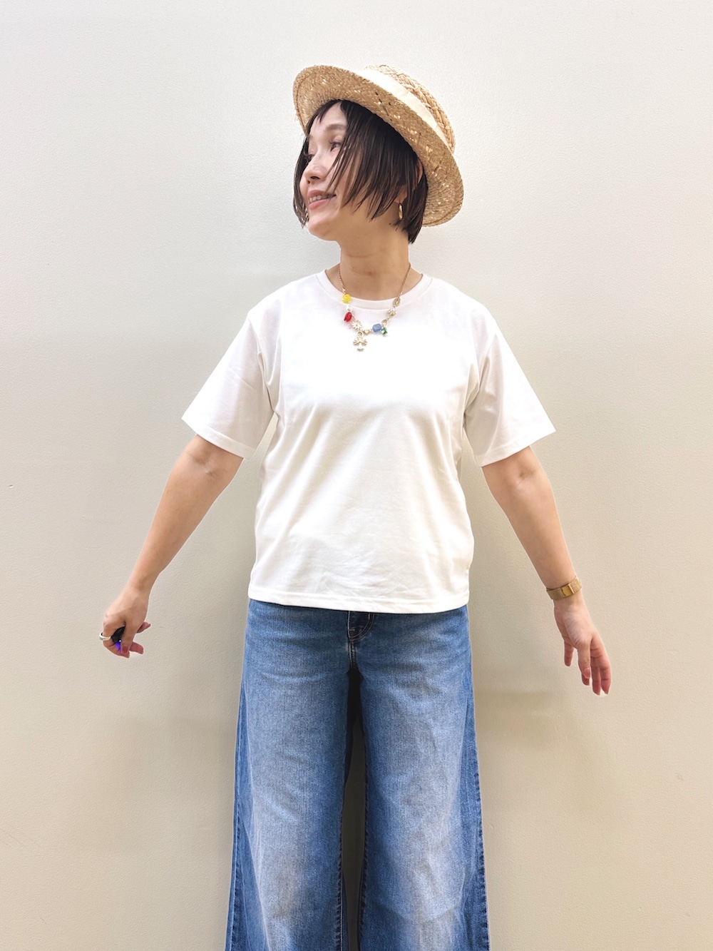 ホワイト系のTシャツ/カットソー、ブルー系のデニムパンツ、ゴールド系のハンドバッグを着用したレディースの夏コーディネートの6枚目の写真