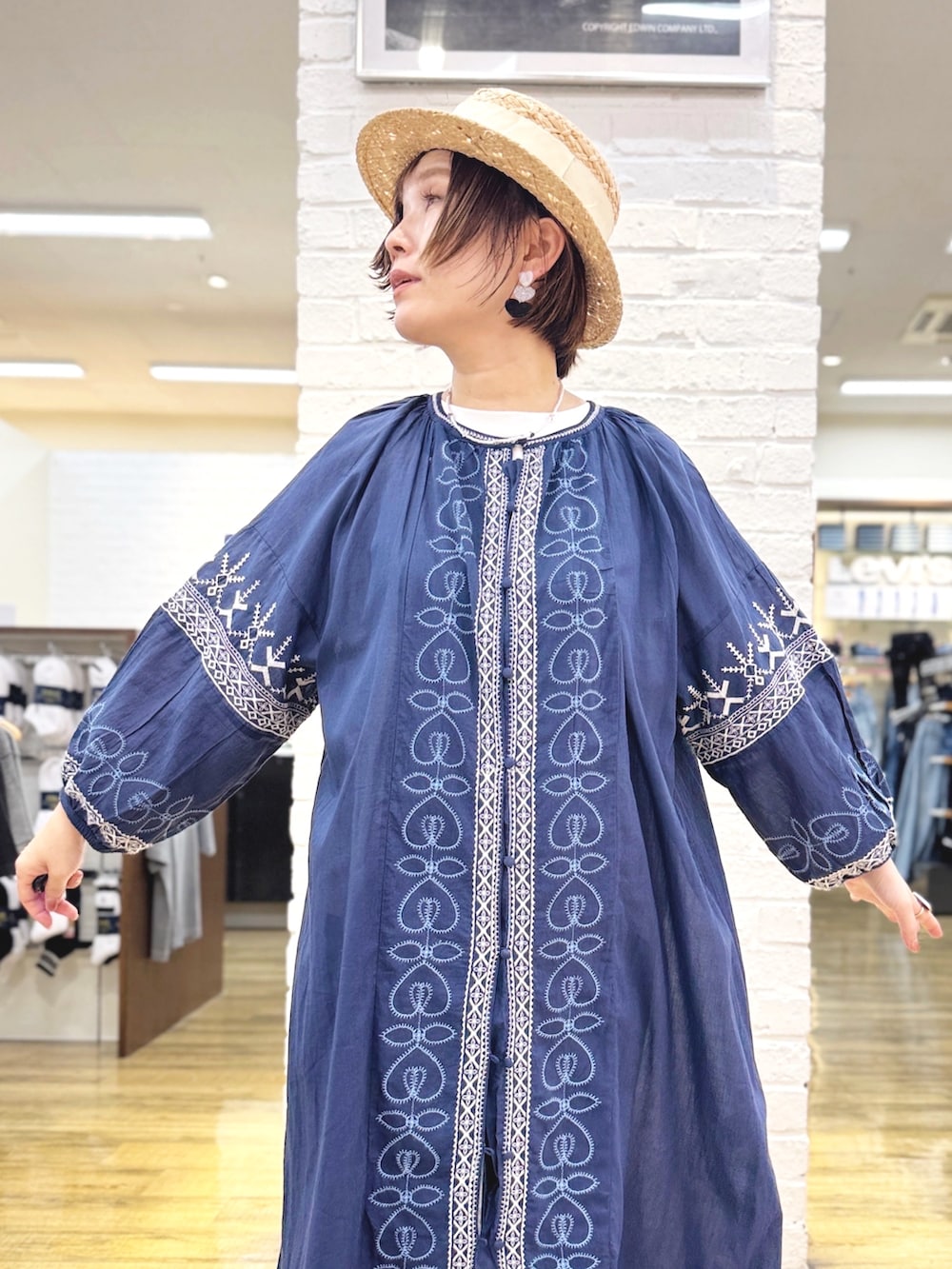 ホワイト系のTシャツ/カットソー、ブルー系のデニムパンツ、ゴールド系のハンドバッグを着用したレディースの夏コーディネートの2枚目の写真