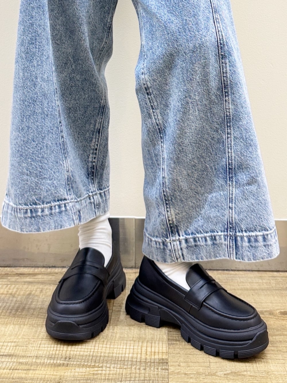 ブラック系のショルダーバッグ、ブラック系のその他シューズ、ブルー系のデニムパンツを着用したレディースの秋コーディネートの9枚目の写真