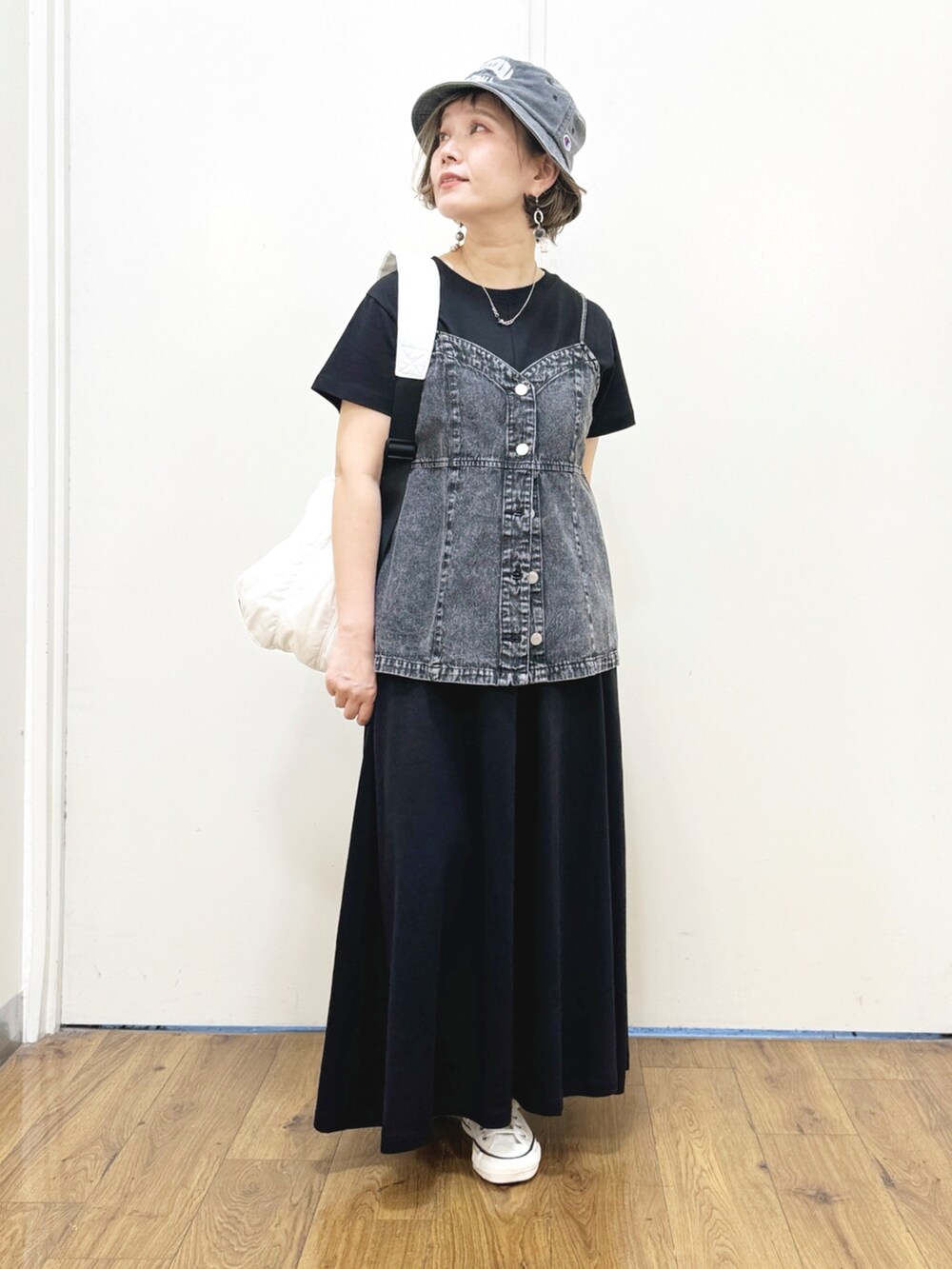 ブラック系のTシャツ/カットソー、ブラック系のキャミソール、ホワイト系のショルダーバッグを着用したレディースの春コーディネートの4枚目の写真