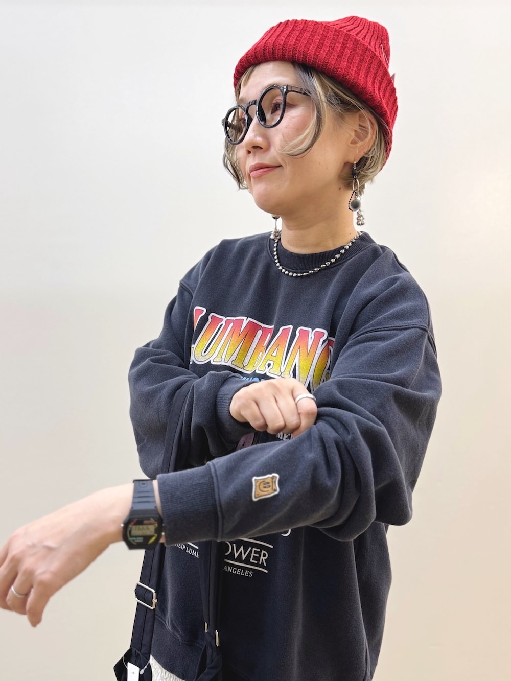 ホワイト系のスカート、ブラック系のスニーカー、ブラック系のショルダーバッグを着用したレディースの秋コーディネートの4枚目の写真