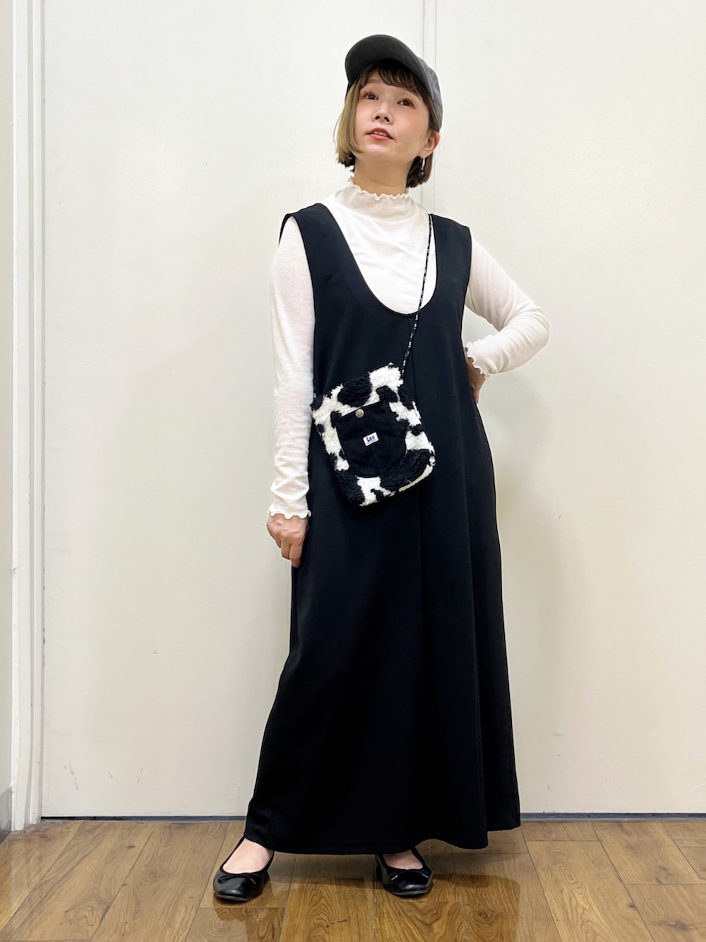 ブラック系のショルダーバッグ、ブラック系のサロペット/オーバーオール、ホワイト系のTシャツ/カットソーを着用したレディースの秋コーディネートの5枚目の写真