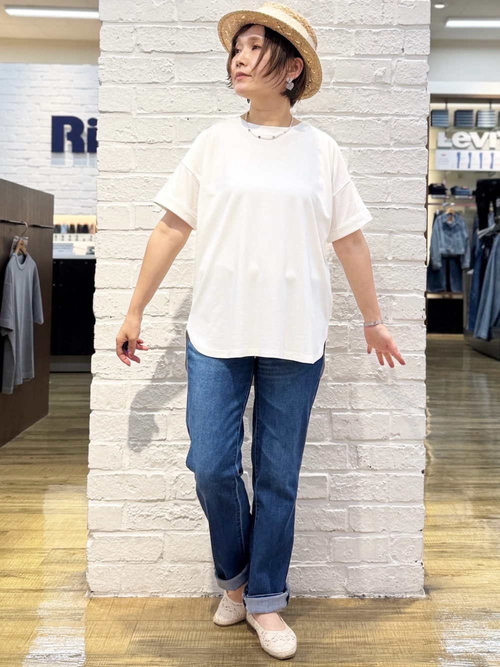 ブルー系のデニムパンツ、ブルー系のシャツワンピース、ホワイト系のTシャツ/カットソーを着用したレディースの春コーディネートの5枚目の写真