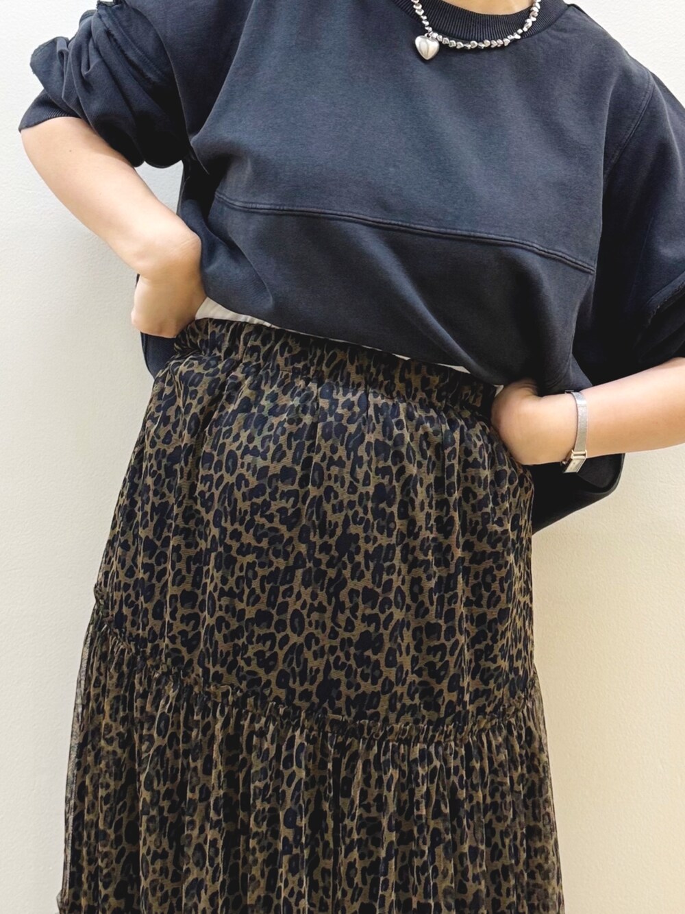 ブラック系のスウェット、ブラウン系のスカート、ホワイト系のショルダーバッグを着用したレディースの秋コーディネートの8枚目の写真